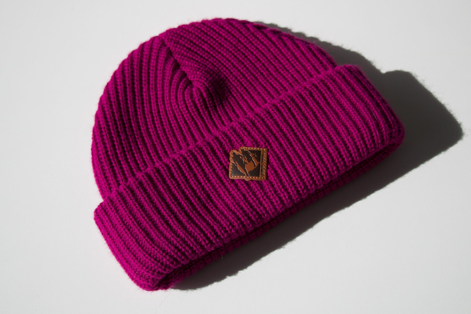bonnet-magenta-etiquette-cuir Bonnet en grosse maille magenta avec étiquette en cuir personnalisée