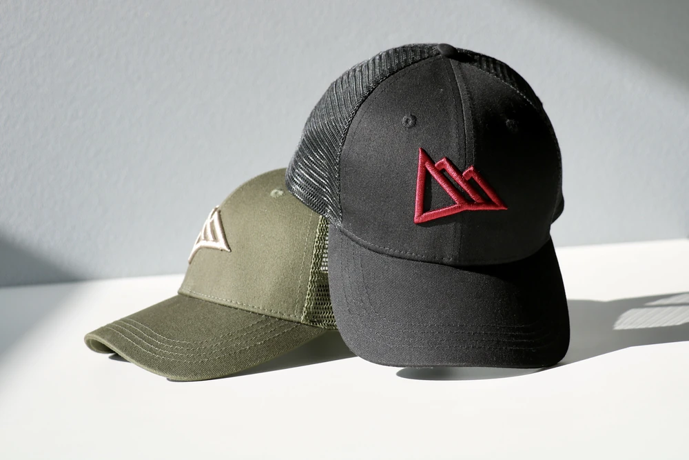 Deux casquettes trucker kaki et noire brodées en 3D du logo Région Dents du Midi