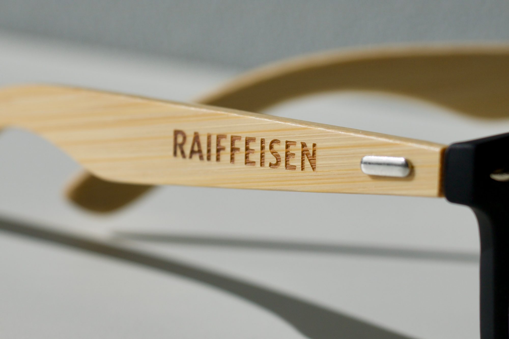 lunettes-soleil-bambou-raiffeisen-gravure-detail Gravure laser Raiffeisen sur une branche de lunettes en bambou