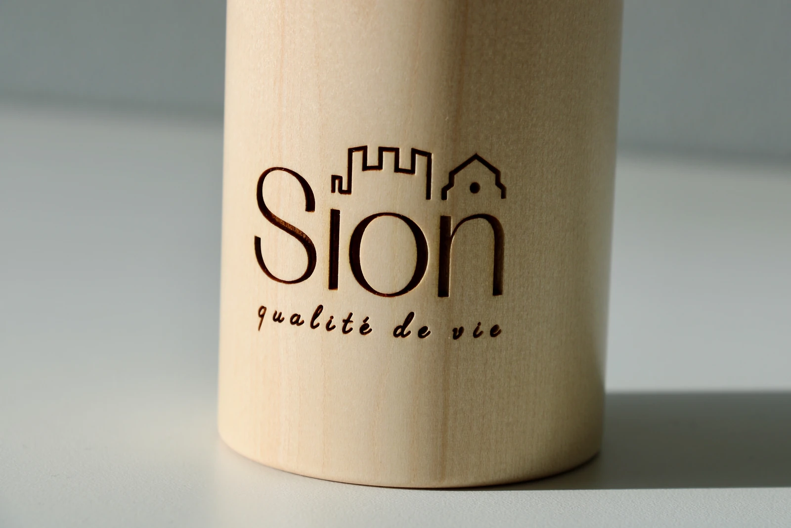 moulin-a-epices-bois-grave-sion-detail-texorio-martigny Détail du logo Sion qualité de vie gravé sur un moulin à épices en bois