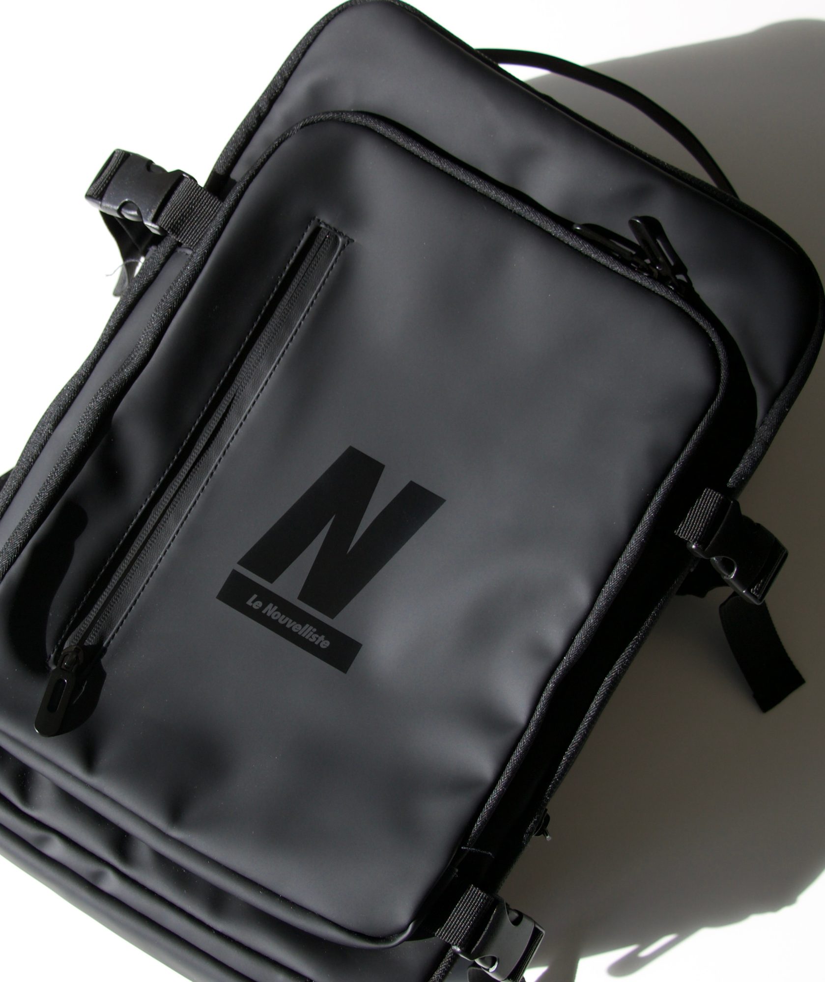 sac-a-dos-personnalise-le-nouvelliste Sac à dos gris déperlant personnalisé avec une gravure laser du logo Le Nouvelliste