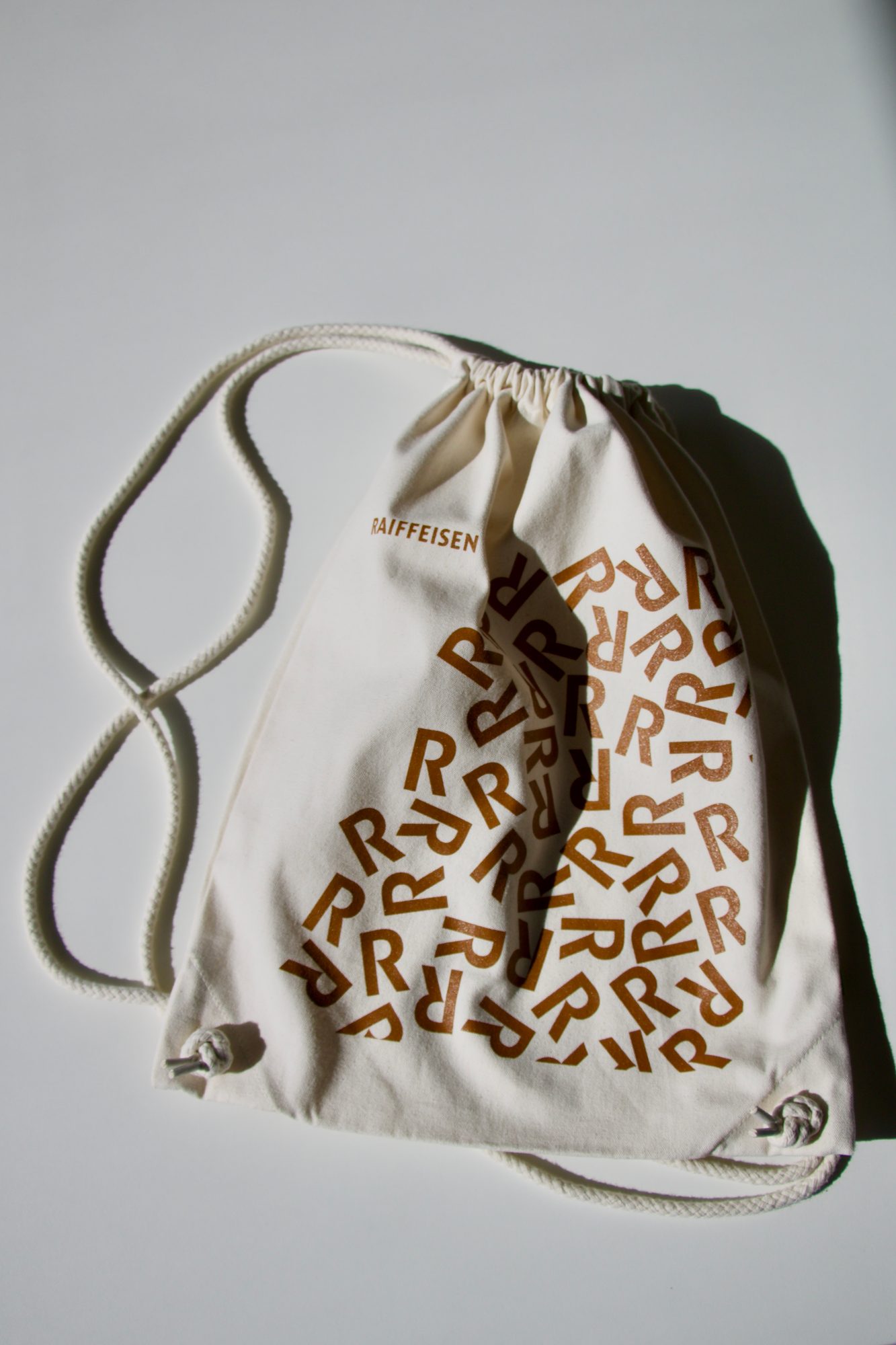sac-cordon-coton-raiffeisen Sac à cordon en coton écru imprimé en sérigraphie du motif R de Raiffeisen